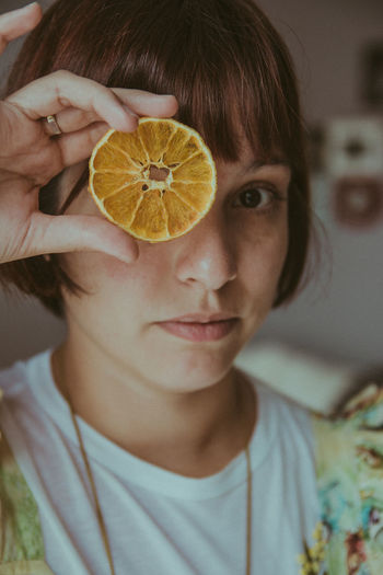 Close-up portrait of woman holding fruit