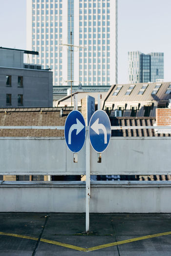 Road sign against buildings in city