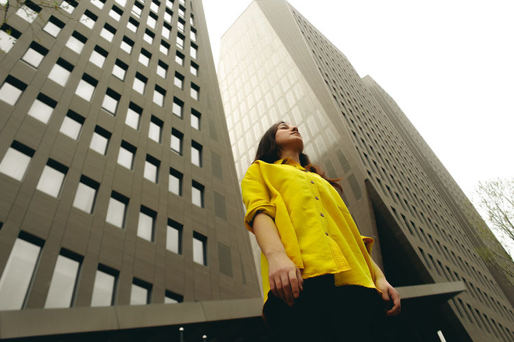 Low angle view of woman standing against building