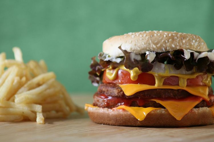 Close-up of cheeseburger with french fries on table