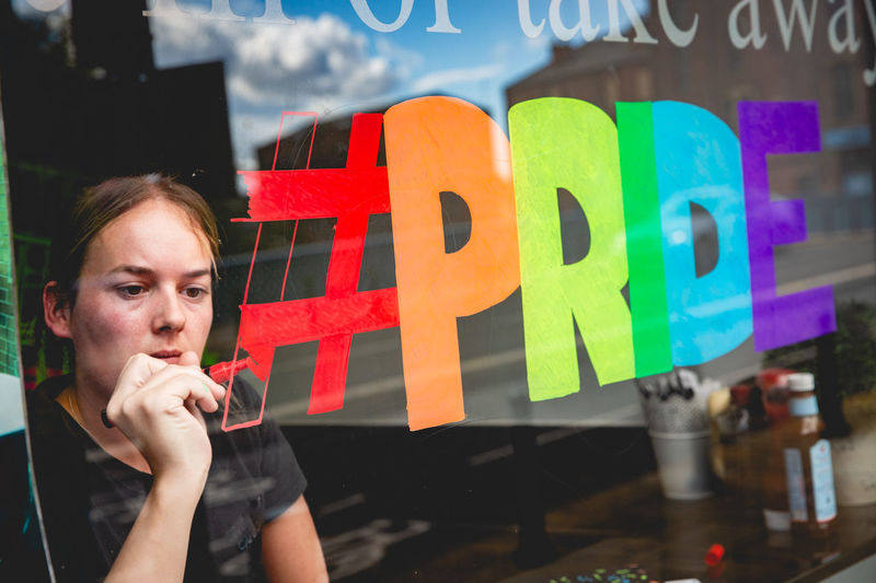 Girl painting a rainbow flag  in support of gay pride parade