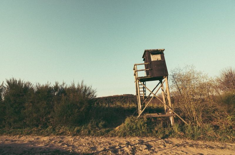 Lookout tower on landscape against clear sky