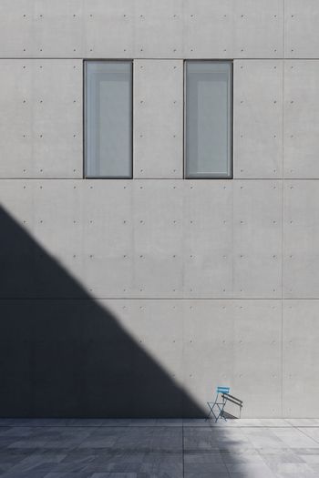 Shadow of person on footpath against building