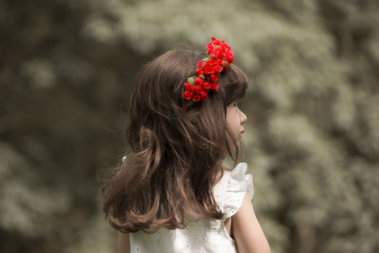 Close-up of cute girl wearing red flowers