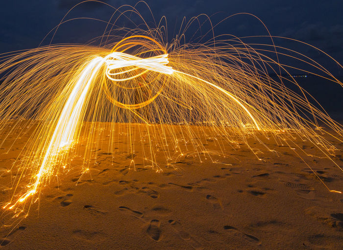 Wire wool on shore against sky at night