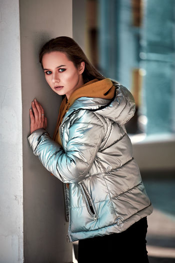 Portrait of woman standing against wall