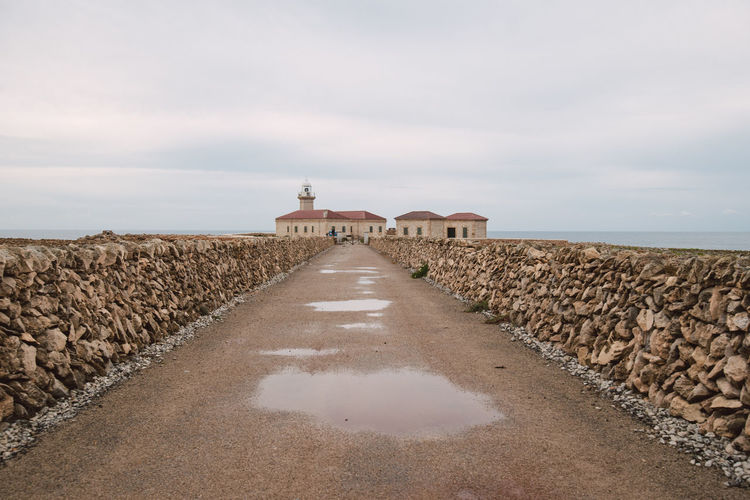 Footpath by sea against sky