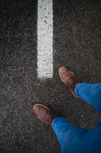 Low section of man standing on road