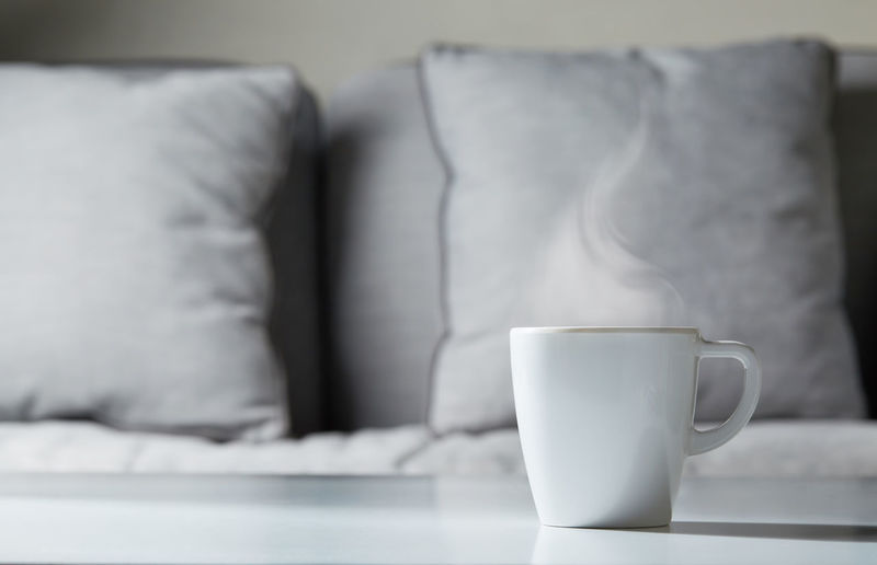 Coffee cup on sofa at home