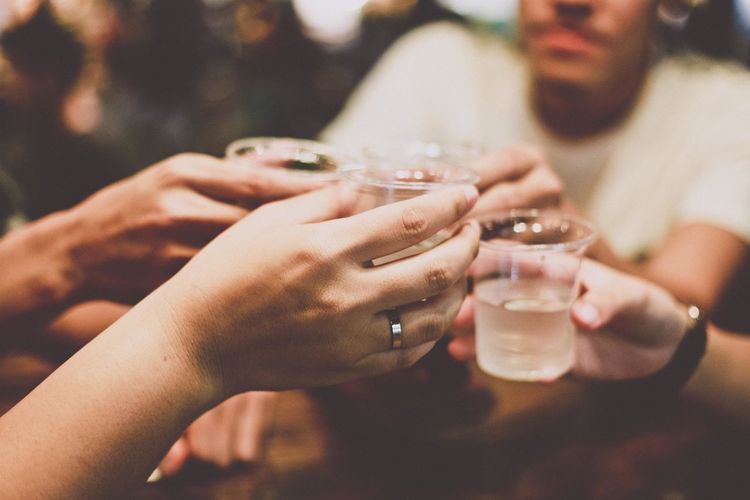 Cropped hands of friends toasting drinks in restaurant