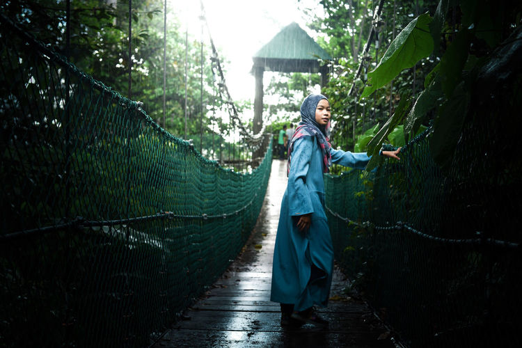 Woman walking on bridge in rain