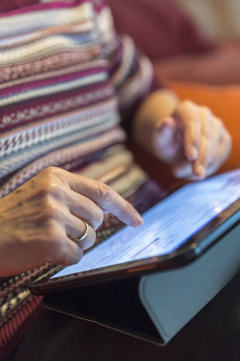 Senior woman using tablet at home, close-up