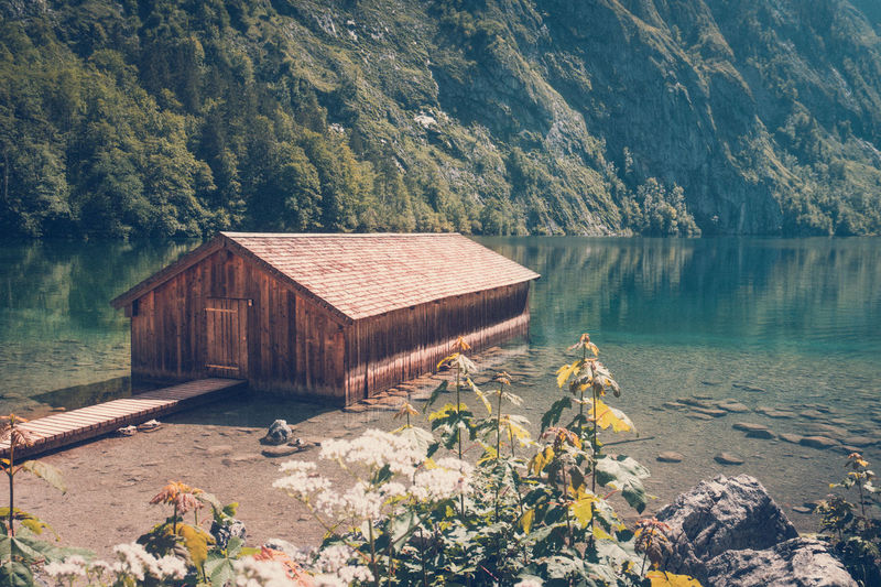 Hut by lake against mountain