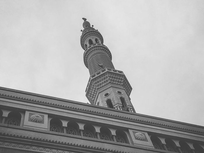 Low angle view of minaret against sky in city