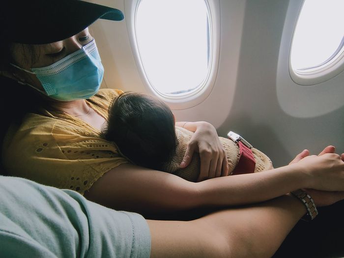 Midsection of couple sitting in airplane