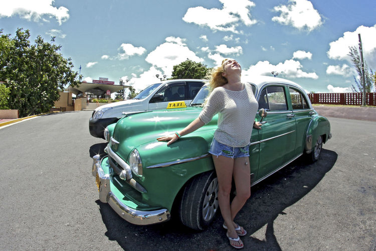 Full length of woman standing by car