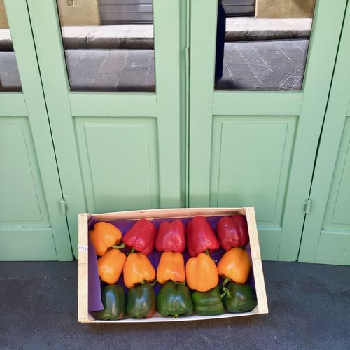 High angle view of colorful bell peppers in box by door