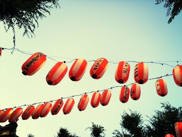 Low angle view of japanese lanterns hanging against clear sky