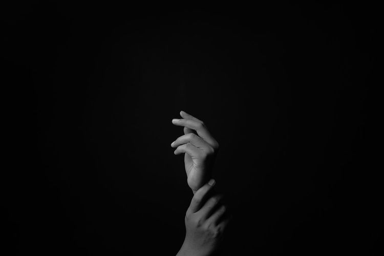 Close-up of woman hand against black background