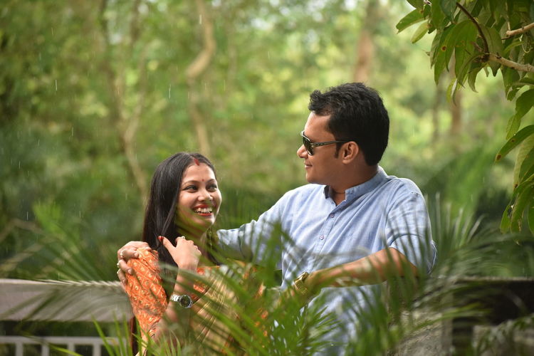 Smiling young couple against plants