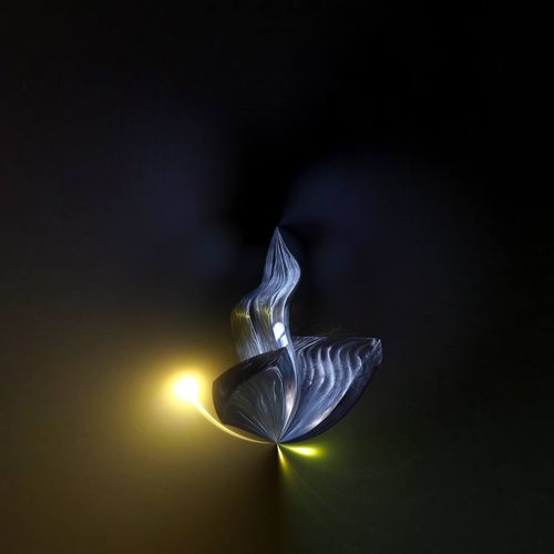 Close-up of illuminated light bulb against black background