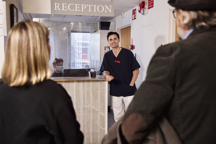 Patients and doctor at reception desk