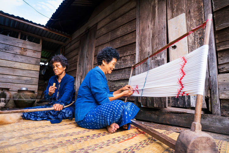 View of women working on loom