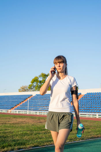 Full length of man standing on field against clear sky