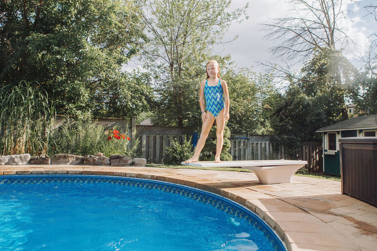 Full length of girl standing by swimming pool