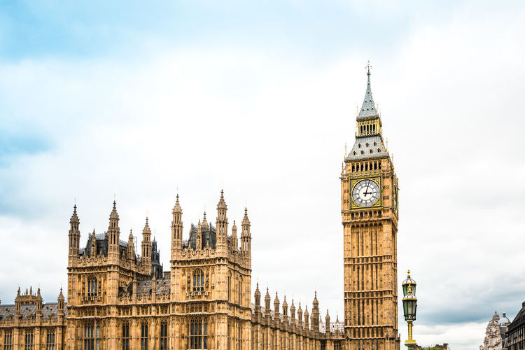 Big ben and houses of parliament against cloudy sky