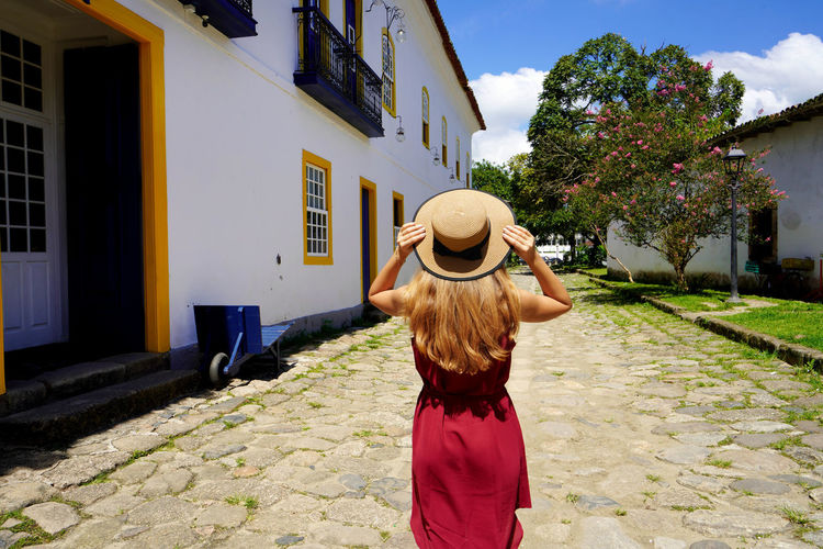 Traveler girl walks through the streets in preserved historic colonial town of paraty, brazil
