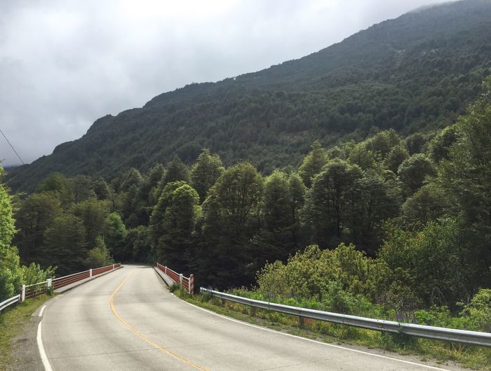 Scenic view of road by mountains against sky