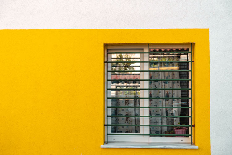 Close-up of yellow window on wall