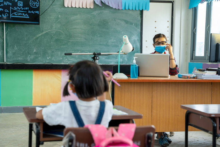 Teacher wearing protective mask to protect against covid-19 with