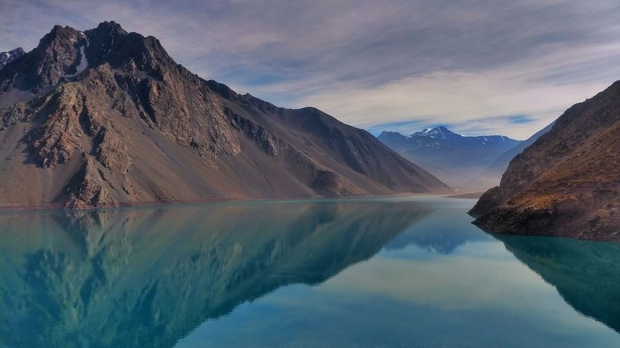 Scenic view of lake by mountains against sky
