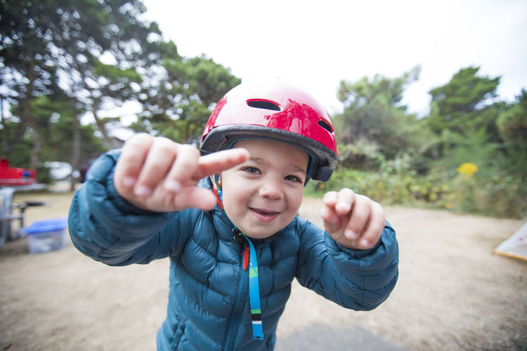 Toddler boy playing outdoors with helmet on.
