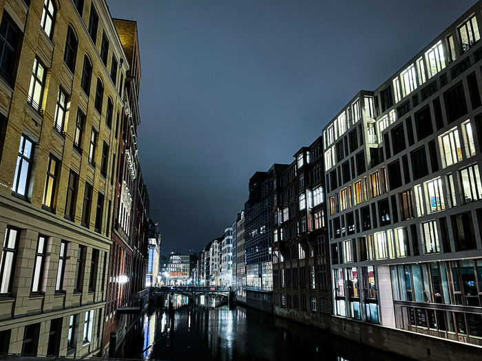 Canal amidst buildings against sky in city at night