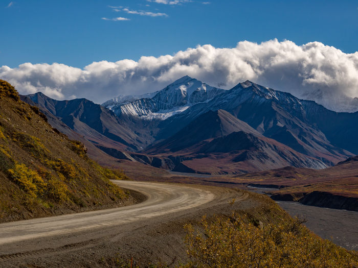 The park road overlooking the autumn tundra and snowcapped peaks in denali national park, alaska.