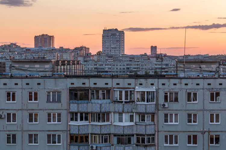 Windows, roofs and facade of an apartment building in russia at evening