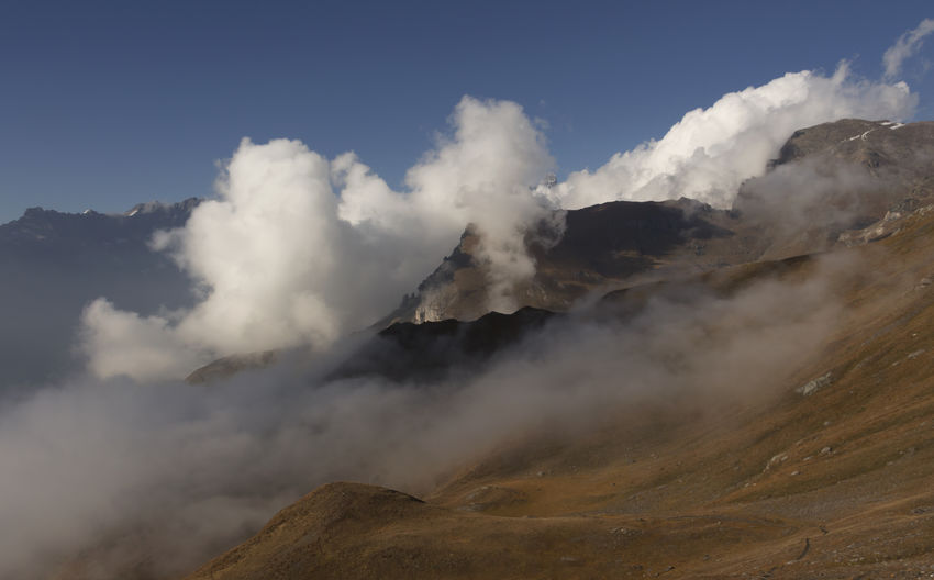 Scenic view of mountain peak surrounded by clouds