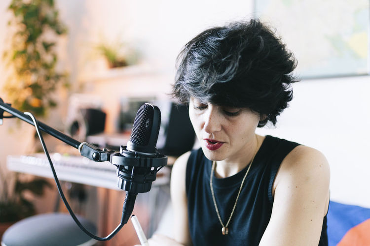 Female musician singing while recording at studio