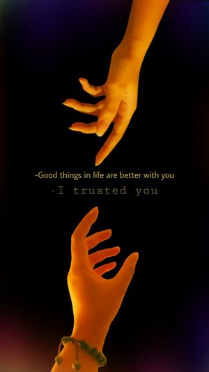 Close-up of hand holding illuminated text against black background