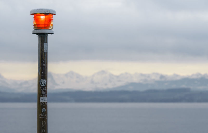 Street light by lake against sky during winter