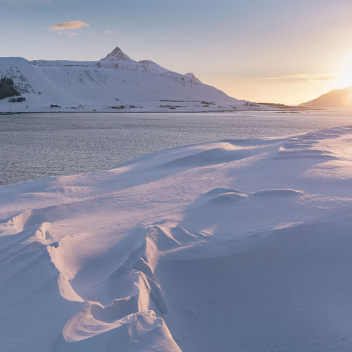Scenic view of snowcapped mountains against sky during sunset