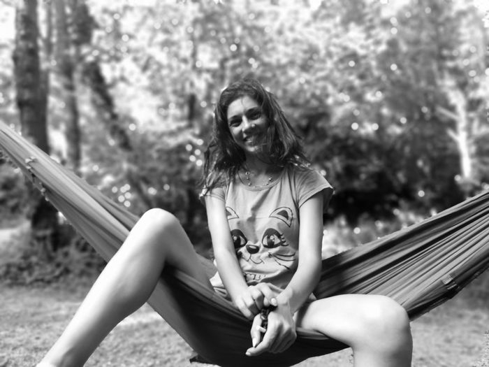 Portrait of woman sitting on hammock outdoors