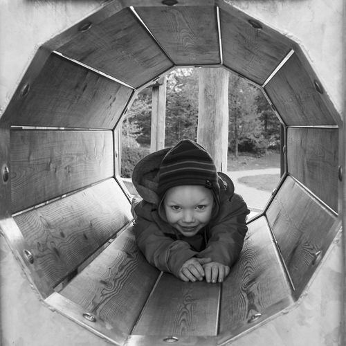 Young boy crowling through a playground 