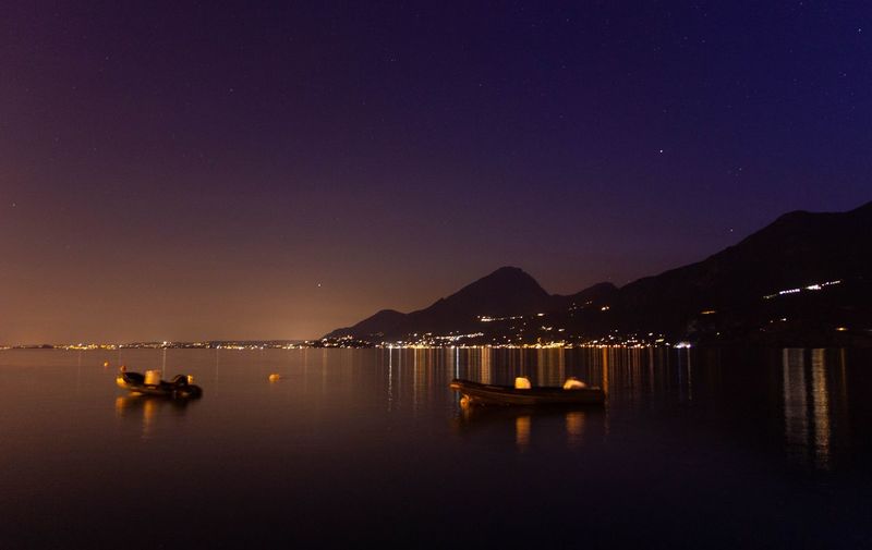 Scenic view of sea against clear sky at night - lago di garda 
