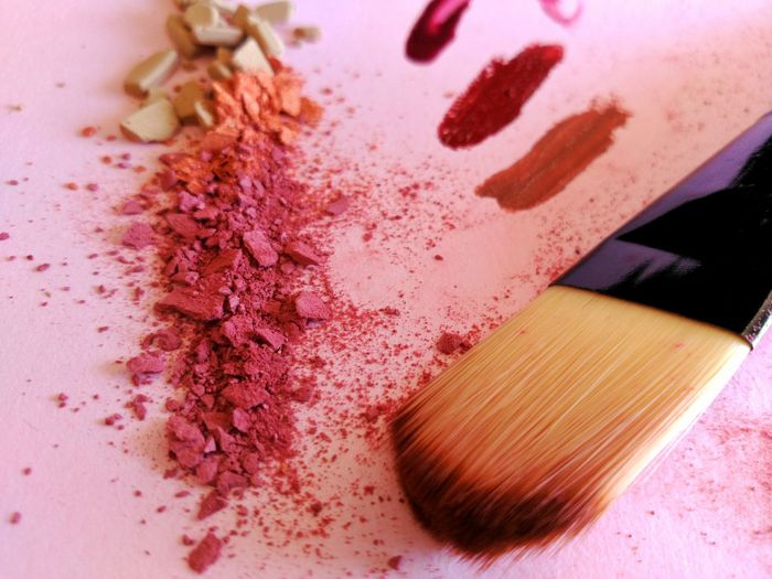 Close-up of make-up brush and blush on table