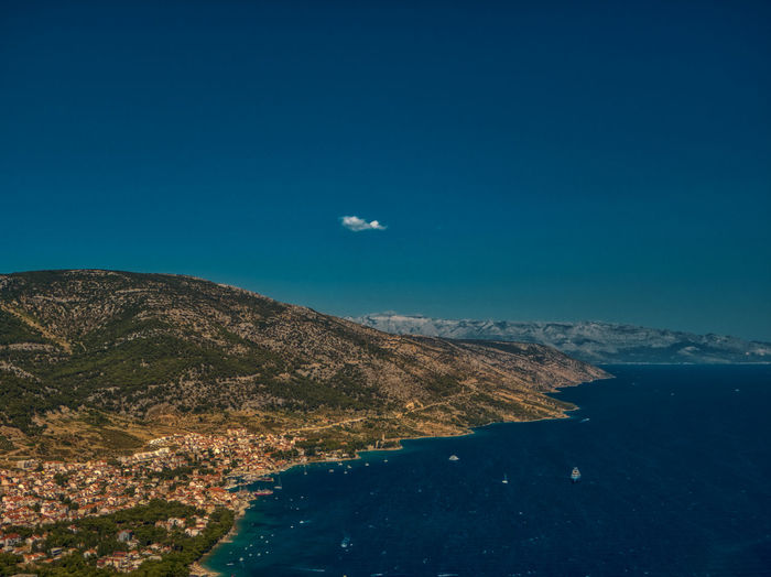 Scenic view of land and mountains against clear blue sky