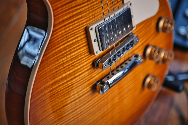 Close up of a solid body electric guitar with a beautiful wooden sunburstt finish